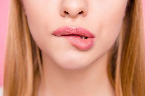 Fillers plump plastic herpes surgery concept. Close up cropped photo of big full natural with lipgloss lips teeth biting lips blonde hair hairstyle isolated on background