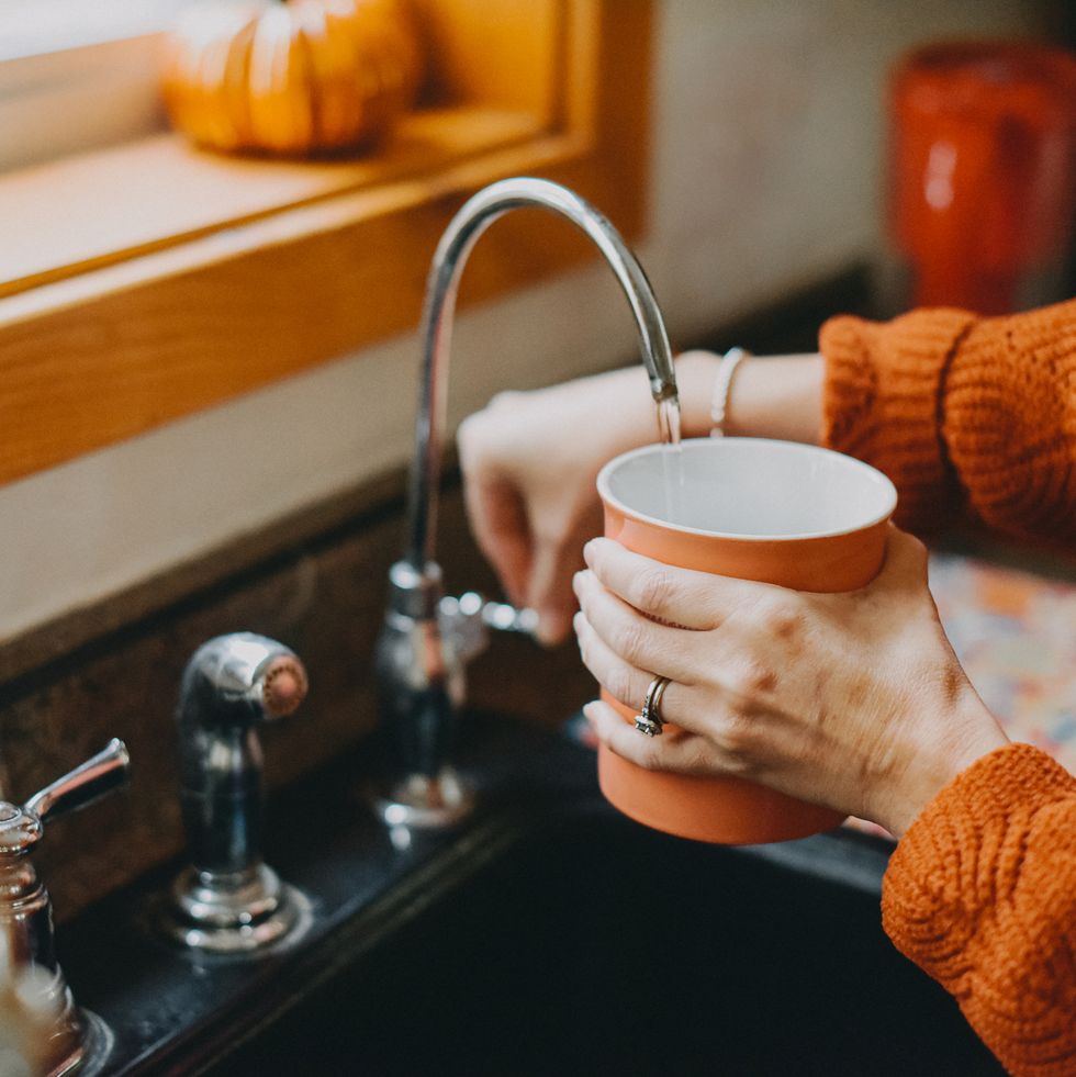 filling a mug with water from faucet
