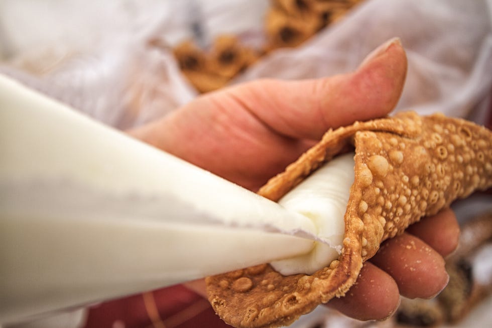 filling cannoli with sweet ricotta from pasty bag