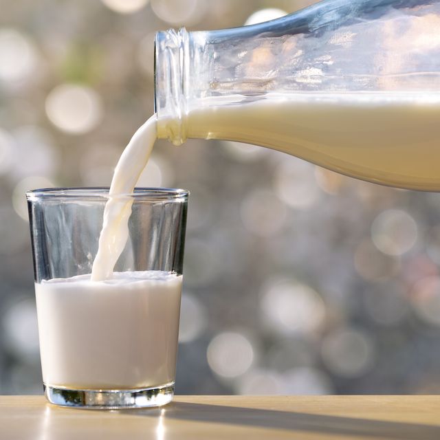 filling of a glass of milk in a glass glass with natural light