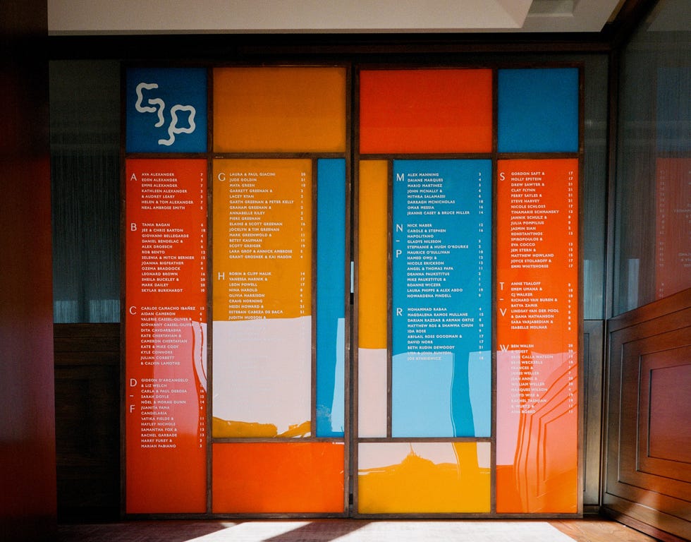 een kleurrijke muur met zitplaatsen voor een bruiloft vermeld