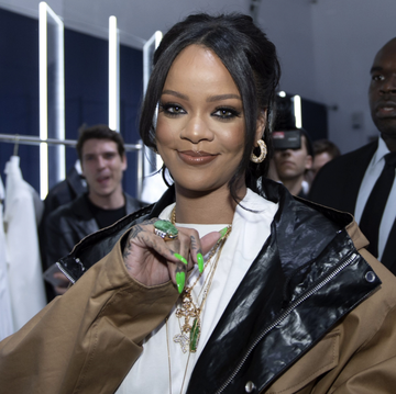 left rihanna at a fenty show right rihanna's new kitchen, featuring marble counters and a gold light fixure