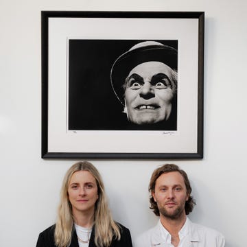 two individuals standing in front of a framed artwork