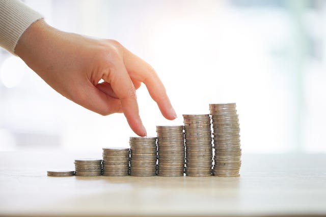 Hand reaching over a stack of coins