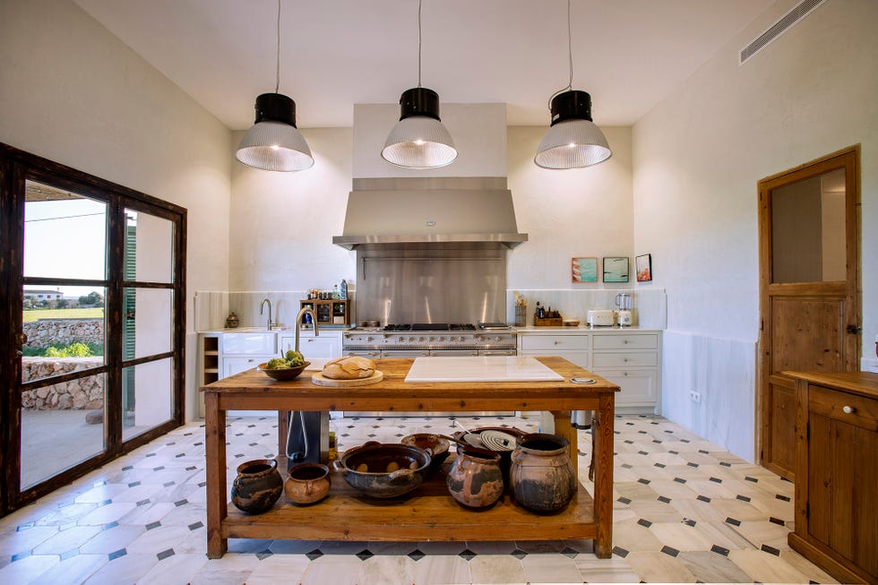 Cocina con isla central, amplios ventanales y cocina Lacanche