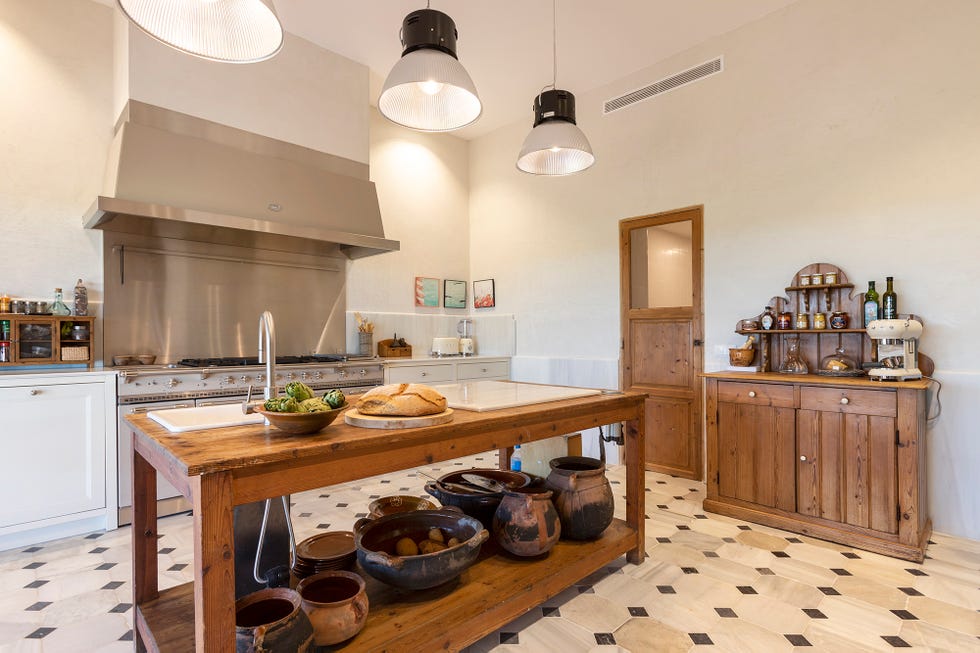 Cocina con isla central de madera y cocina Lacanche