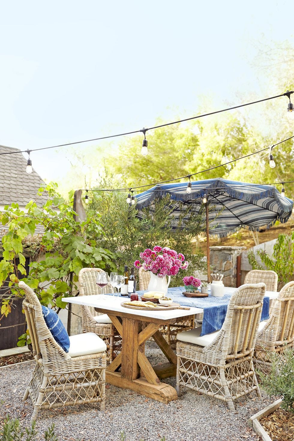 pea gravel dining area with trestle table and wicker chairs