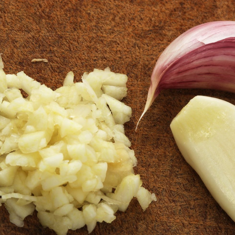 finely chopped garlic on a wooden cutting board