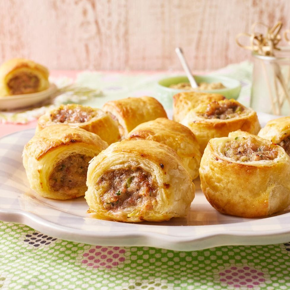 sausage rolls on white plate green background