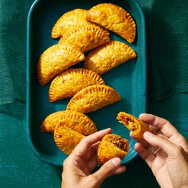 beef empanadas on a blue baking tray