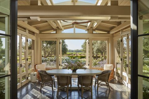 a new screened breakfast porch painted grant beige by benjamin moore overlooks a grove of olive trees and the vineyards beyond