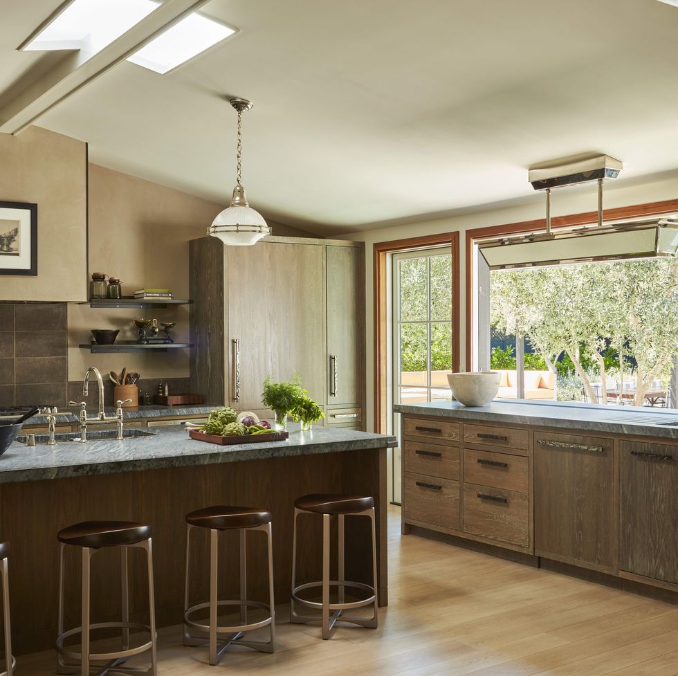in the kitchen cerused white oak cabinetry brazilian soapstone counters and bronze hardware with a pitch ceiling and giant windows