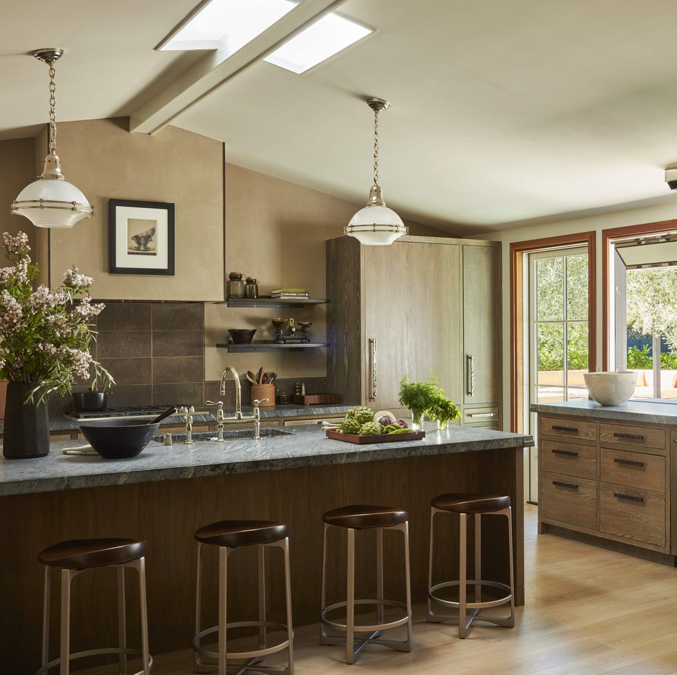 in the kitchen cerused white oak cabinetry brazilian soapstone counters and bronze hardware with a pitch ceiling and giant windows
