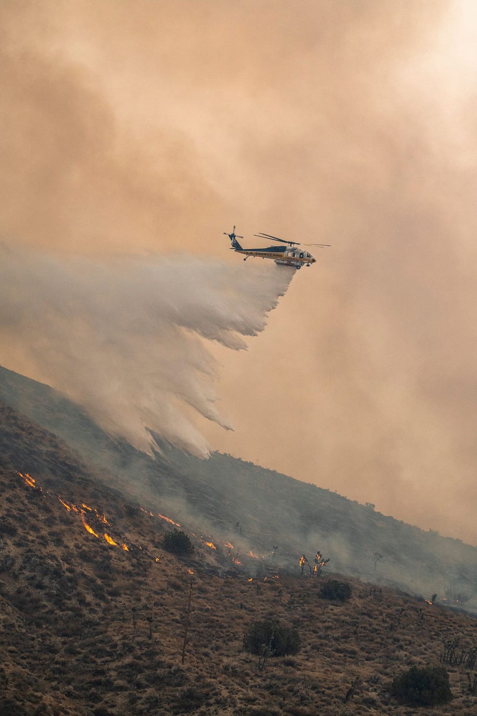 Een Firehawkhelikopter van Los Angeles County werpt in september water af aan het noordfront van de Bobcatbrand De Firehawk een nieuwe aanvulling van de luchtvloot voor de brandbestrijding in Californi haalt hoge snelheden zodat hij brandweerteams in ijltempo bij een brandhaard kan afzetten