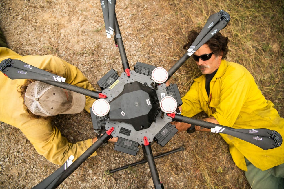 Een drone wordt gereedgemaakt voor het afwerpen van drakeneieren bolletjes ter grootte van een pingpongbal die ontbranden als ze de grond raken De balletjes kunnen in de baan van een oprukkende natuurbrand kleine brandjes veroorzaken zodat de bosbrand te weinig brandstof op zijn pad vindt om zich verder uit te breiden