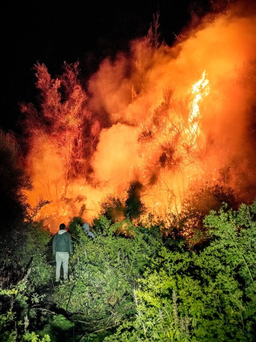 In de buitenwijken van het stadje El Bolsn proberen twee bewoners de vlammen onder controle te krijgen De brand ontstond op 24 januari 2021 door een kampvuur duurde ruim 45 dagen en legde duizenden hectaren bos in de as