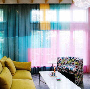 Sheer curtain hand-dyed by Josana Blue a room with a couch and a table with a lamp and a window with curtains