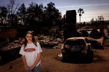 A devastated area with ruins and a burnt car