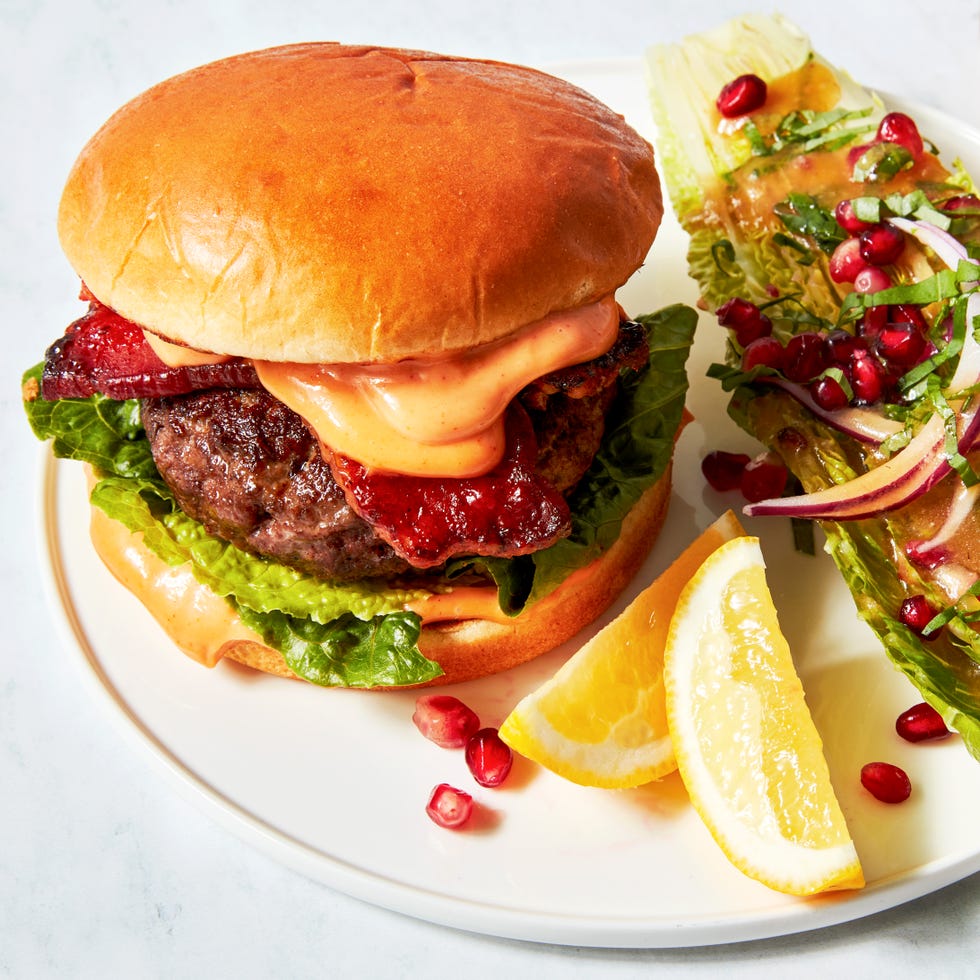 beef burger with bacon, lettuce, and a spicy sauce