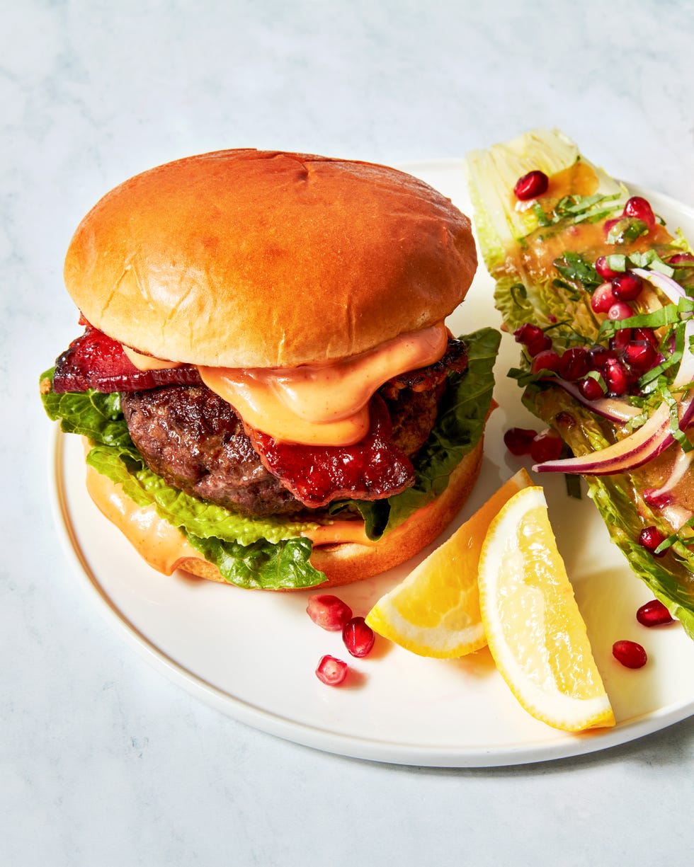 beef burger with bacon, lettuce, and a spicy sauce