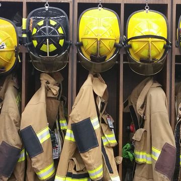 firefighter uniforms with helmet hanging in rack