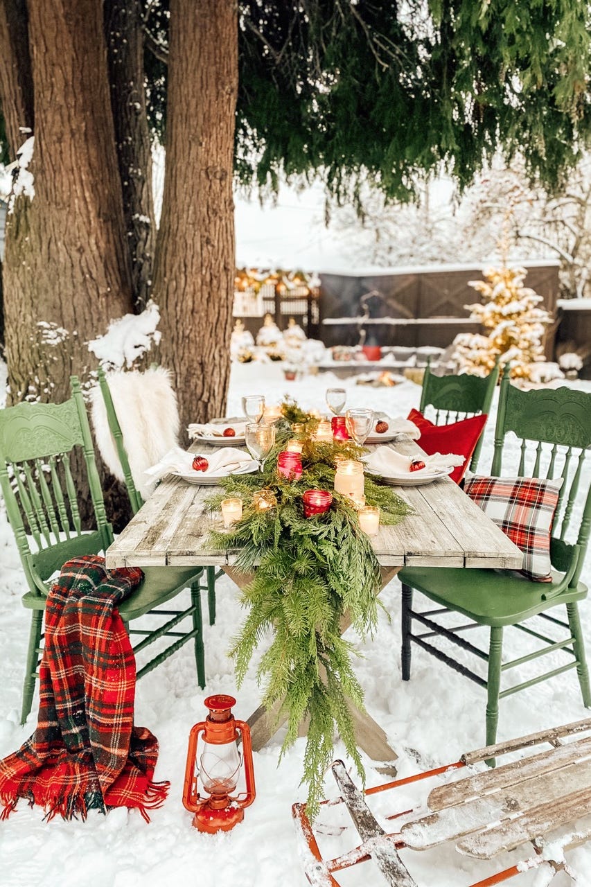 a table with a set of chairs and a tree with a candle on it