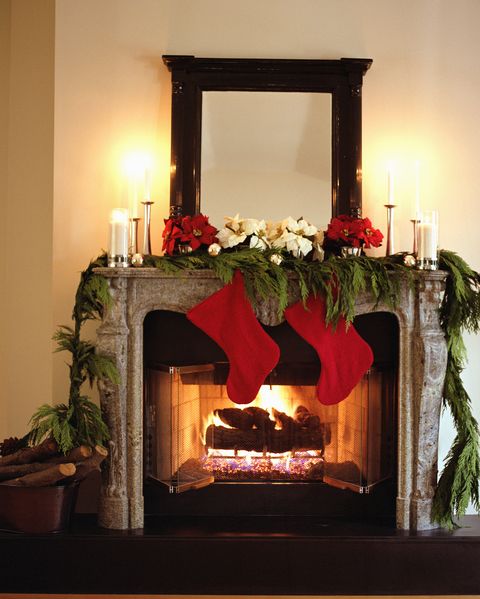 fireplace decorated with christmas stockings and poinsettias