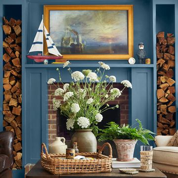 blue living room with matching mantel and built in storage framing a brick fireplace
