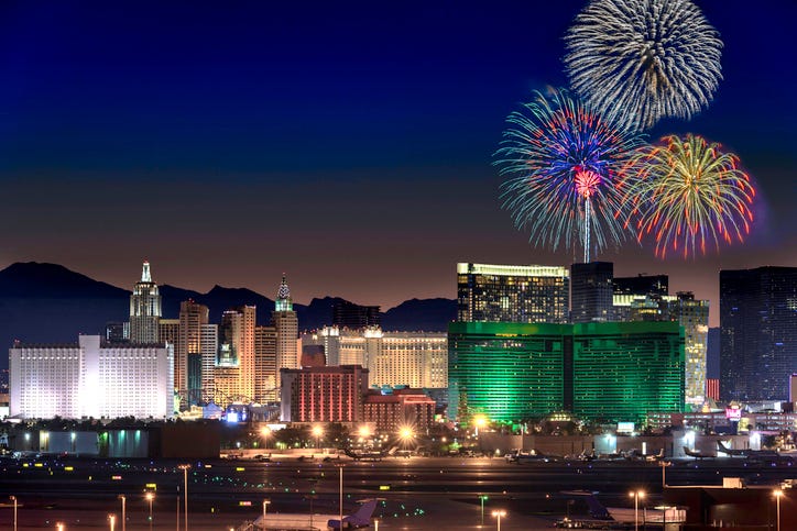 red yellow blue and green fireworks explode over las vegas skyline