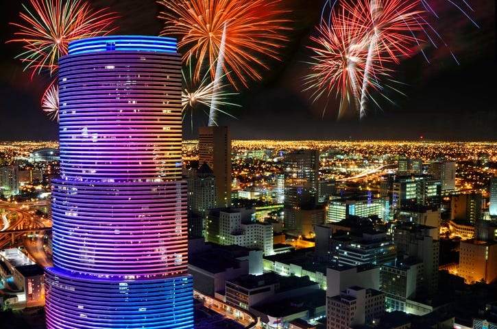 red and green fireworks explode over miami skyline