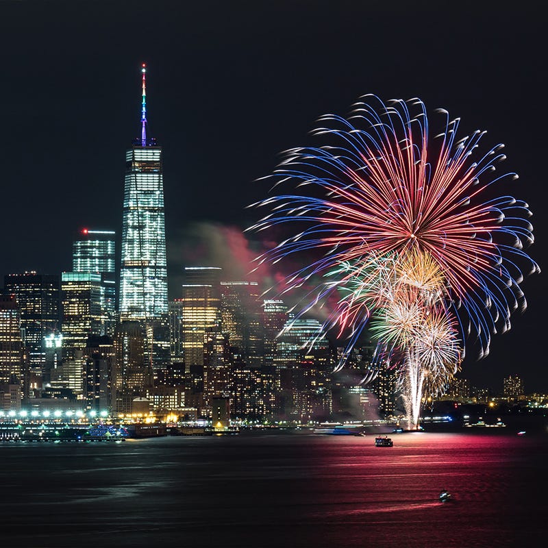 read white and blue fireworks over east river with new york city skyline