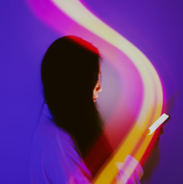 woman holding phone with abstract light over it