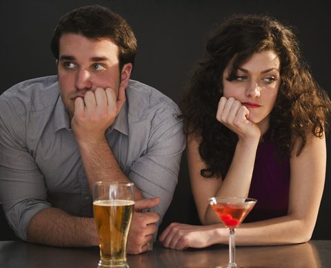 first date questions not to ask man and woman staring into the distance not enjoying themselves at a bar