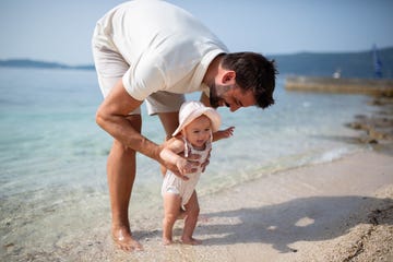bebe en la playa con su padre
