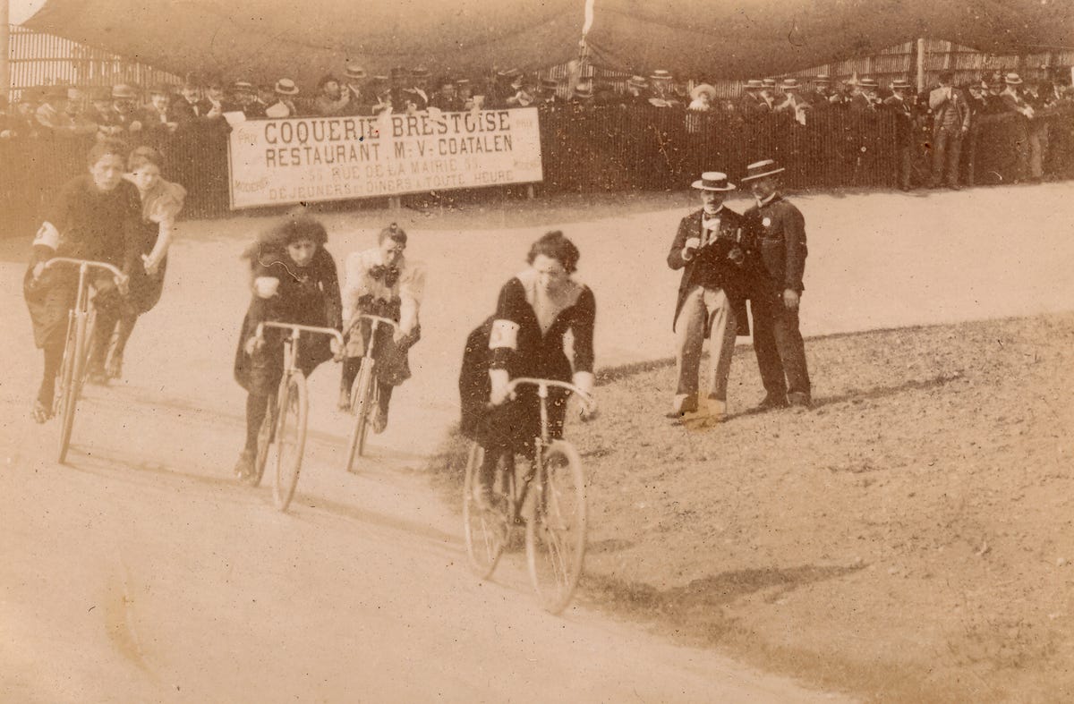 Athletic Young Female In Sports Attire Poses With Her Bicycle