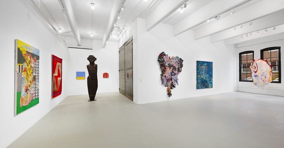 a person standing in a room with art on the wall