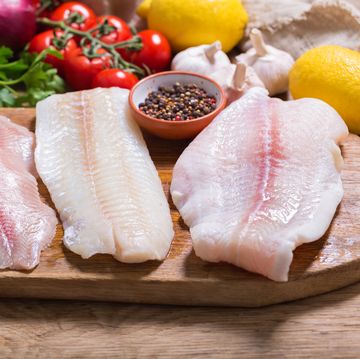 fish fillet of cod, tilapia and pangasius with ingredients for cooking