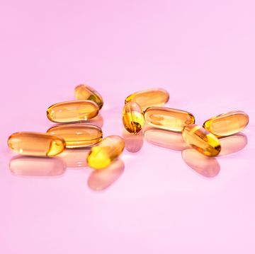 yellow vitamin d supplements on pink background