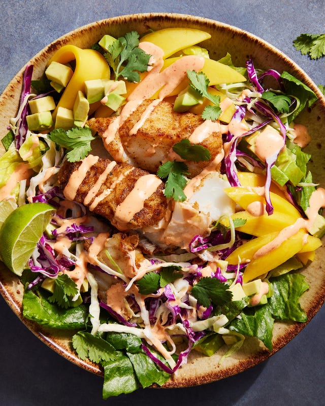 fish taco bowls with cabbage, mango, cilantro and a spicy cream drizzle