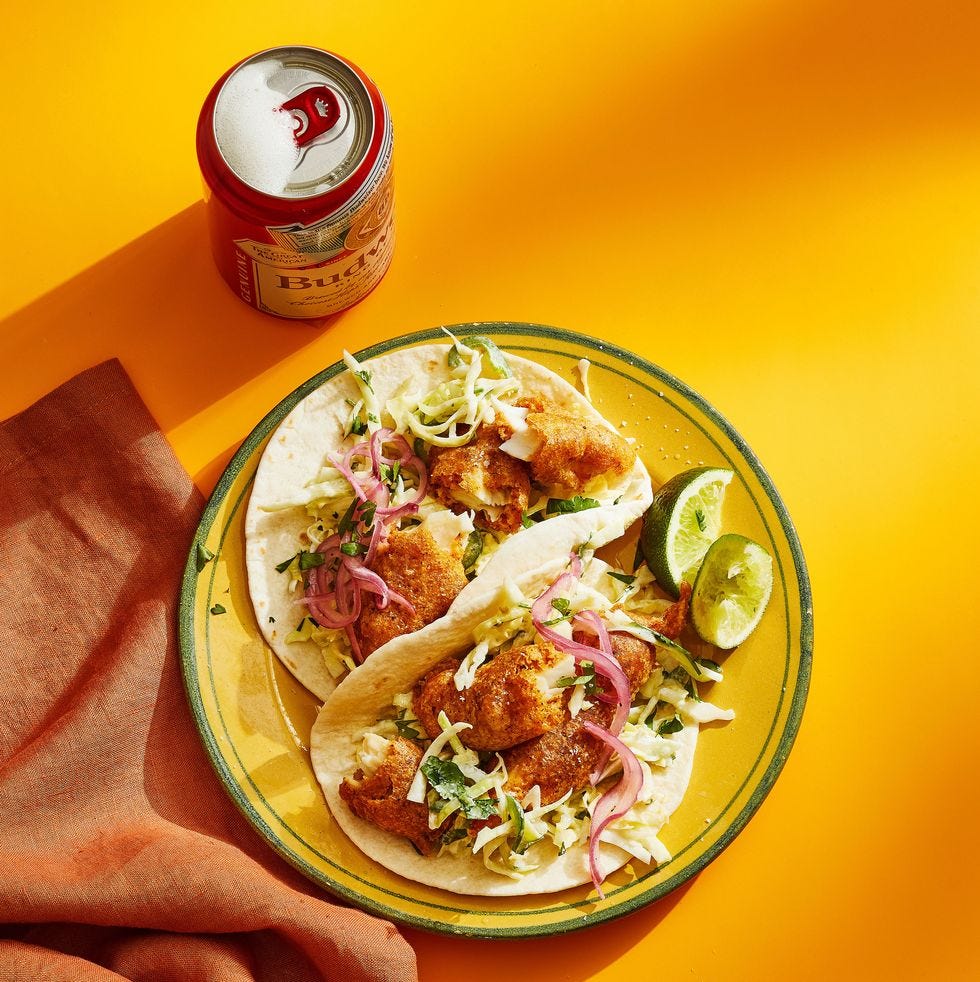 two beer battered fish tacos with red onions on top