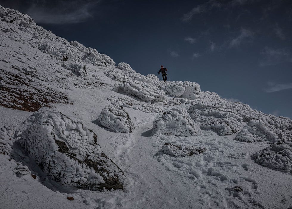 Een bergwandelaar trekt door het besneeuwde landschap rond de berg Asahidake In het park valt elk jaar gemiddeld tussen de dertien en veertien meter sneeuw wat dit gebied tot een uitmuntende wintersportbestemming maakt