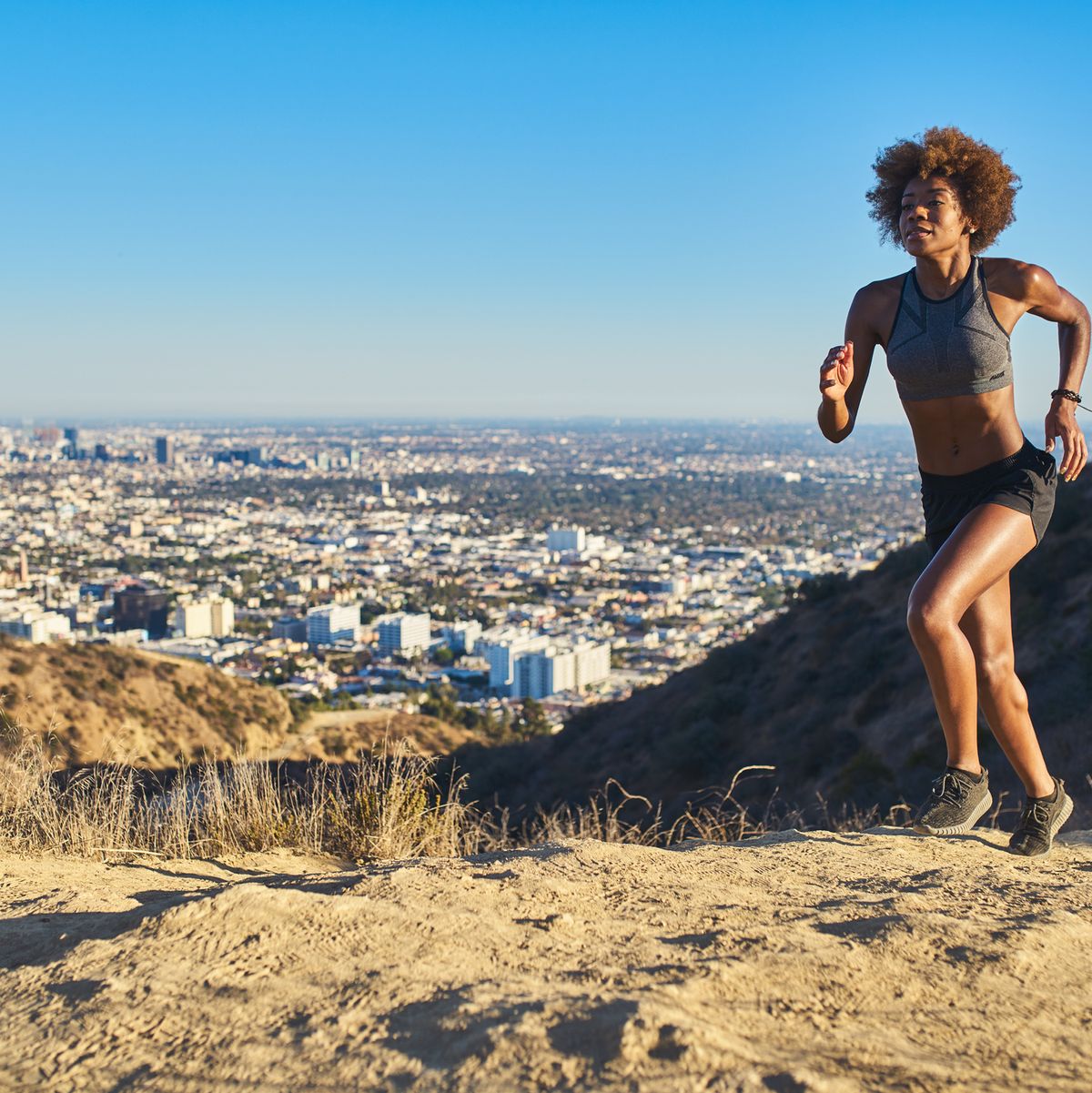 fit african american woman running at runyon canyon with los angeles