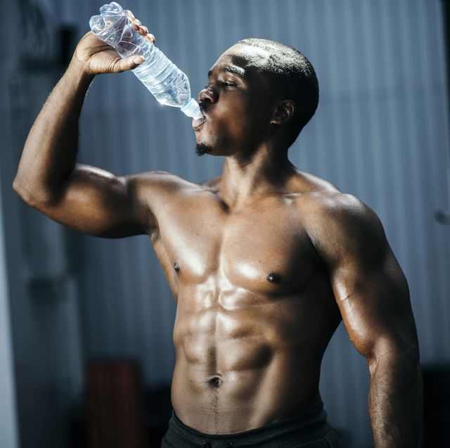 fit and mascular man drinking water