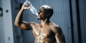 Fit and mascular man drinking water