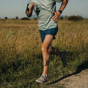 fit anonymous man running in the countryside, cardio workouts concept