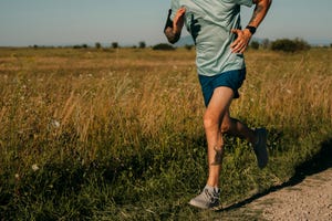 fit anonymous man running in the countryside, cardio workouts concept