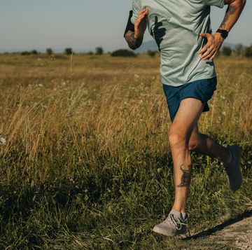 fit anonymous man running in the countryside, cardio workouts concept