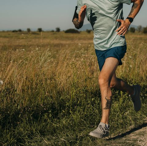 fit anonymous man running in the countryside, cardio workouts concept