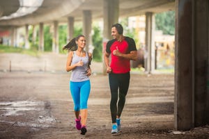 fit attractive couple running outdoors together