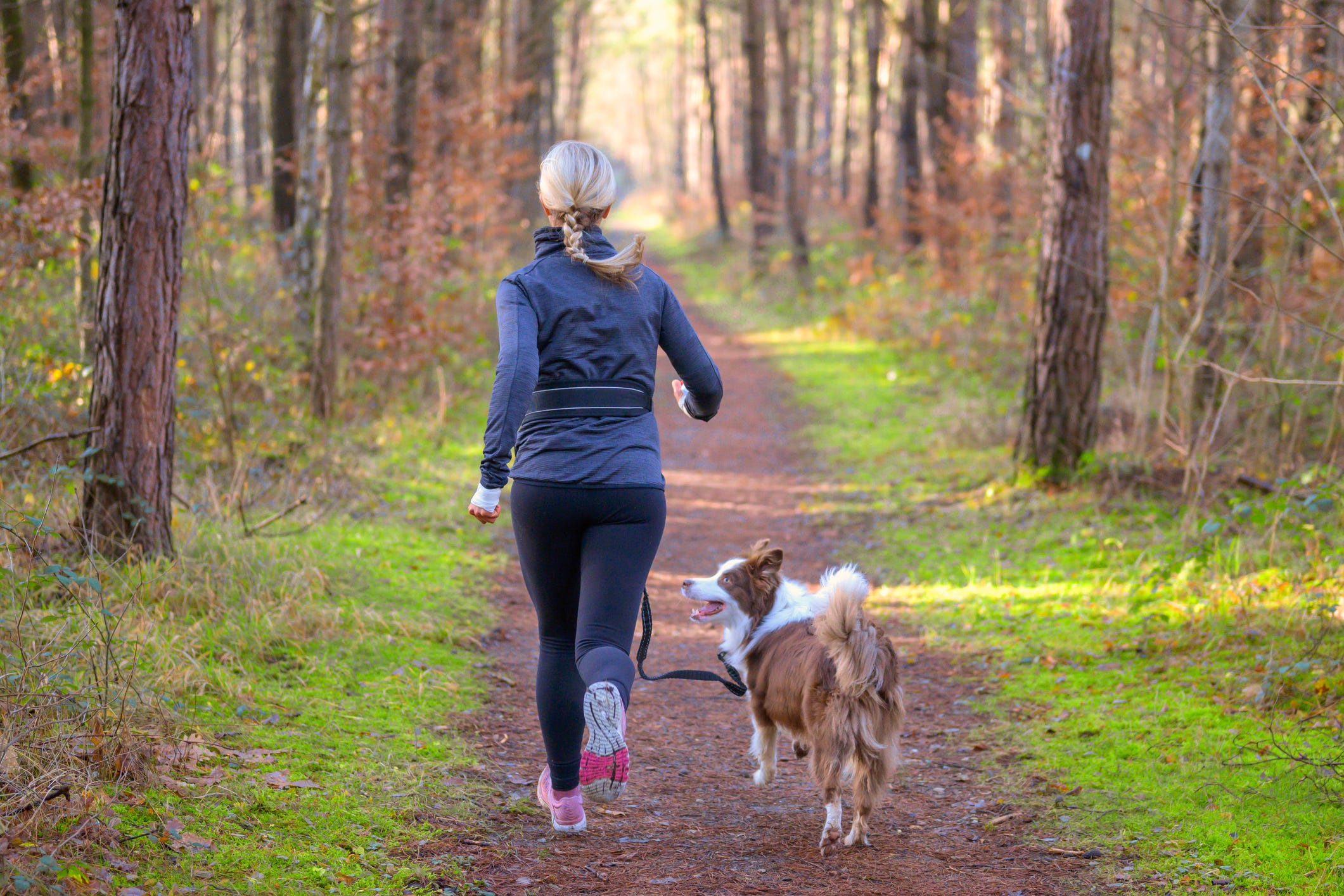 fit blond woman jogging with her dog